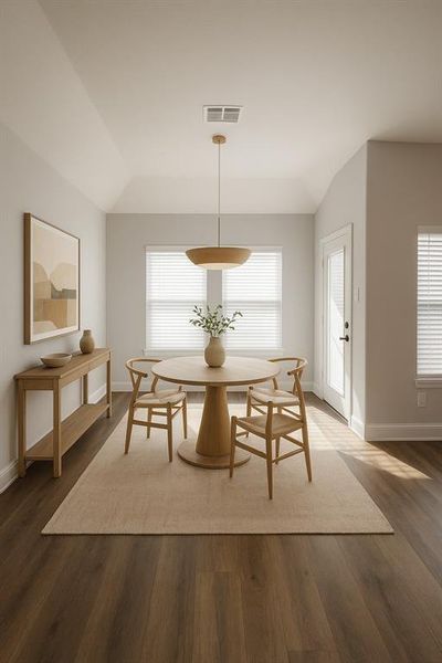 Dining area featuring wood finished floors and vaulted ceiling