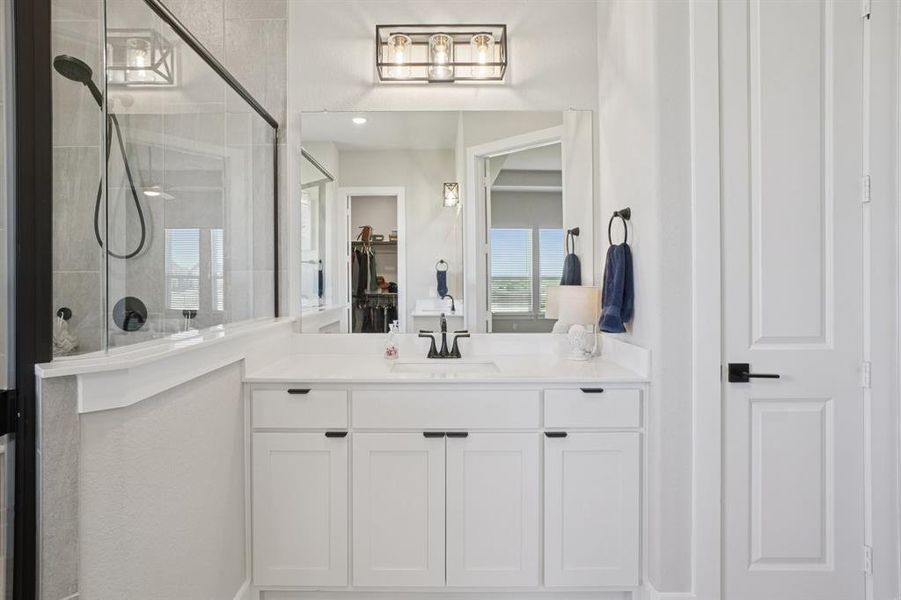 Primary bath with tiled shower, spa bath, separate vanities, and a spacious closet