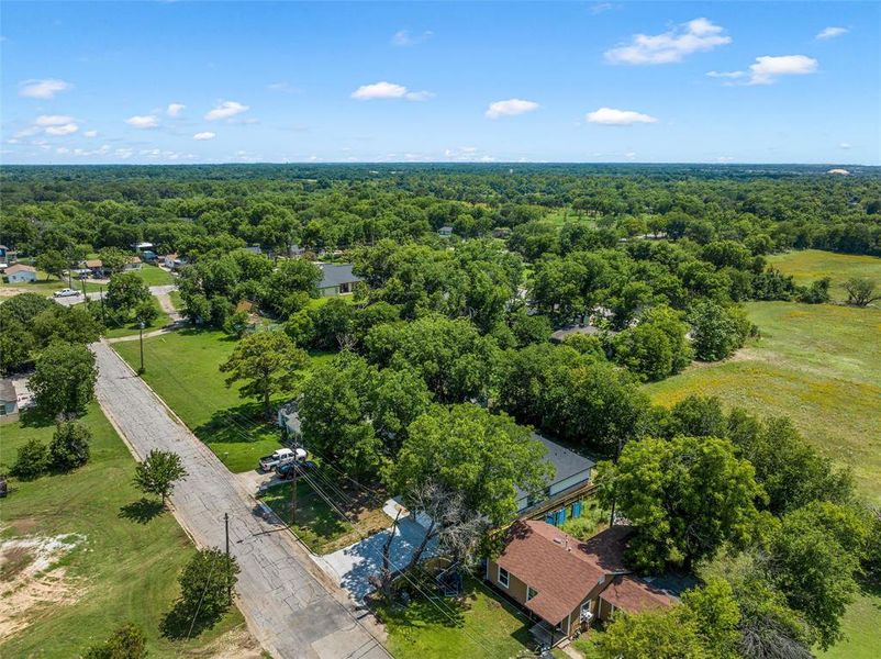 Aerial perspective showcasing a residential property with a reddish-brown roof, surrounded by mature trees Aerial perspective showcasing a residential property with a reddish-brown roof, surrounded by mature trees