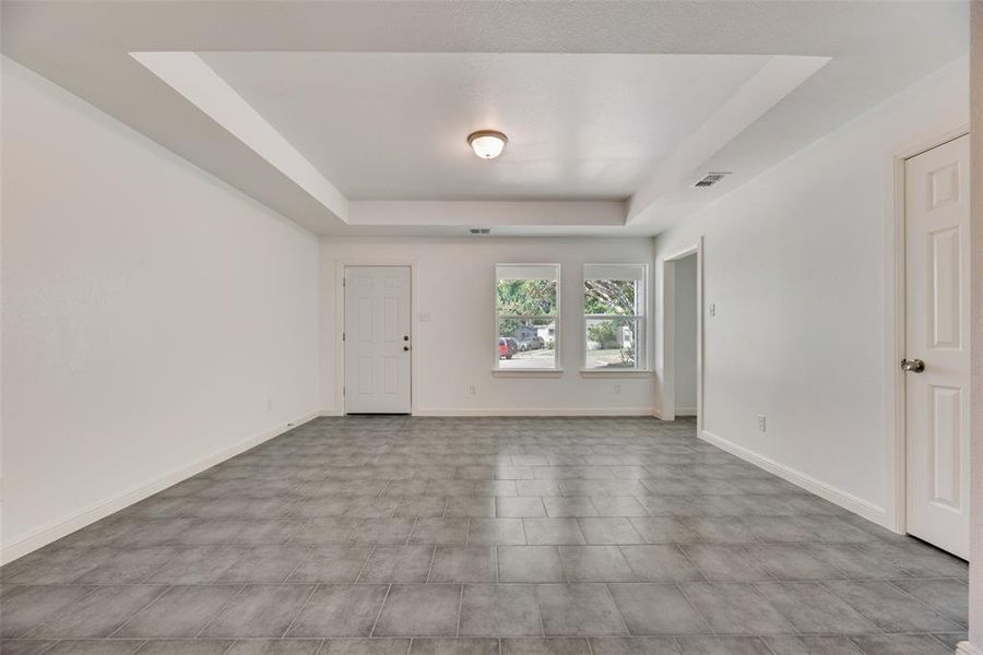 Tiled spare room with a tray ceiling