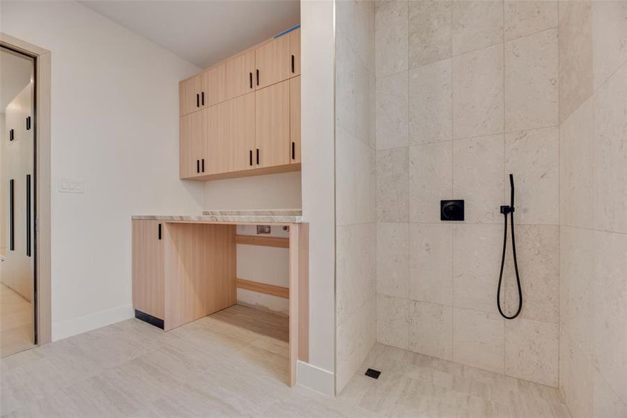 Bathroom featuring tiled shower and tile patterned floors