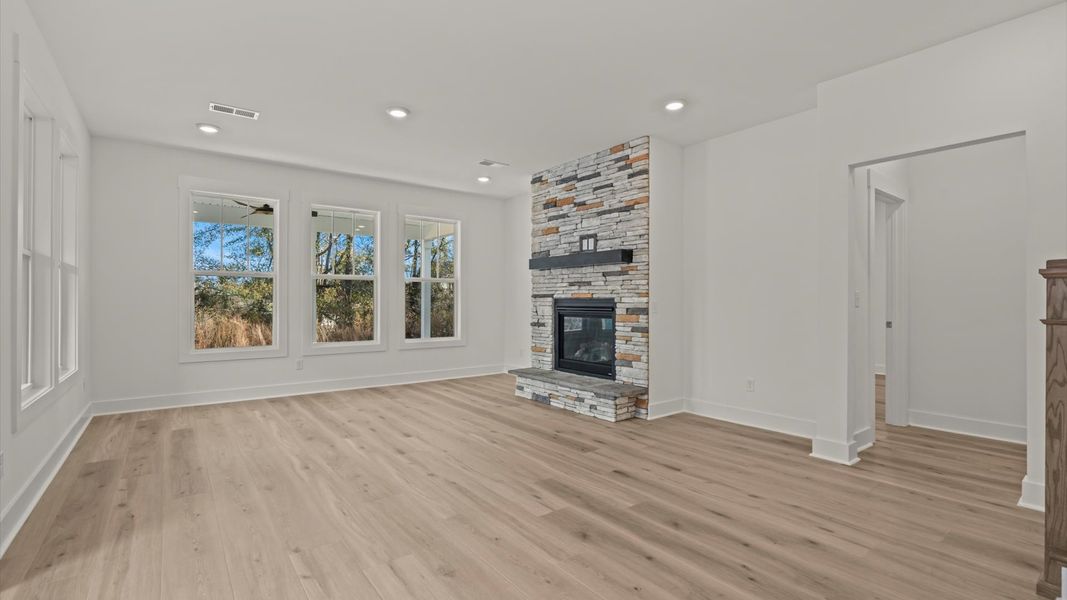 Elegant family room featuring hardwood flooring, large windows, and thoughtful architectural detail
