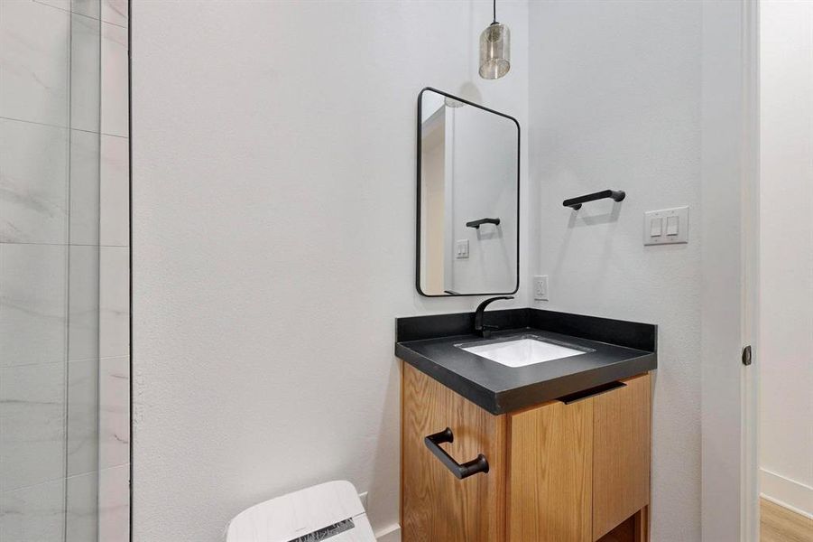 Modern bathroom vanity with a dark countertop, undermount sink, and matte black fixtures Modern bathroom vanity with a dark countertop, undermount sink, and matte black fixtures