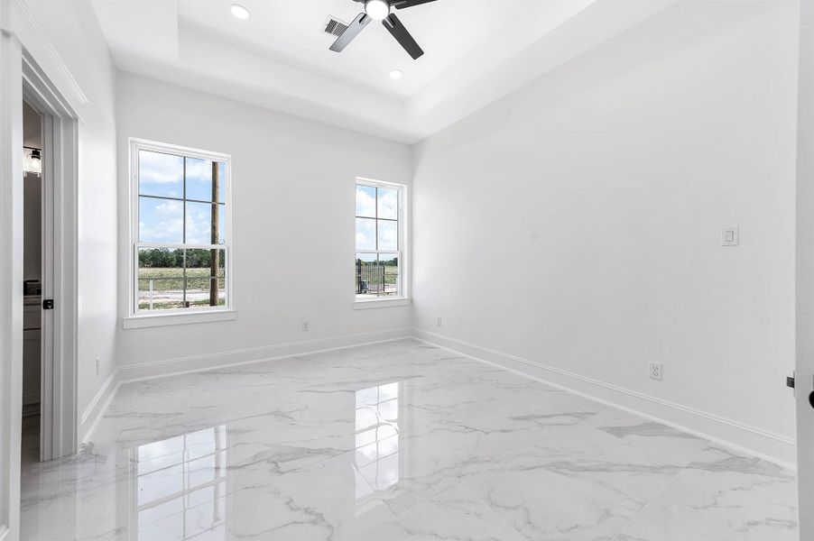 Spacious bedroom featuring high ceilings, modern finishes, and windows that bring in plenty of natural light. Spacious bedroom featuring high ceilings, modern finishes, and windows that bring in plenty of natural light.