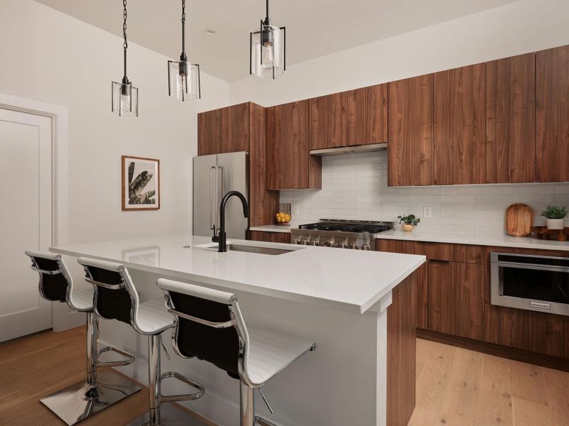 Kitchen with modern cabinets, hanging light fixtures, and brown cabinetry Kitchen with modern cabinets, hanging light fixtures, and brown cabinetry