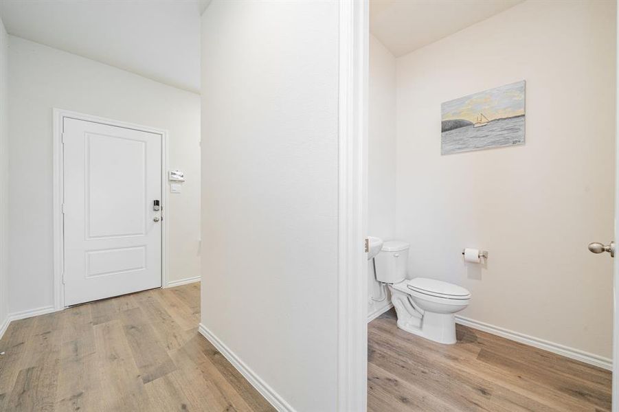 Half bathroom with toilet and light wood-type flooring Half bathroom with toilet and light wood-type flooring