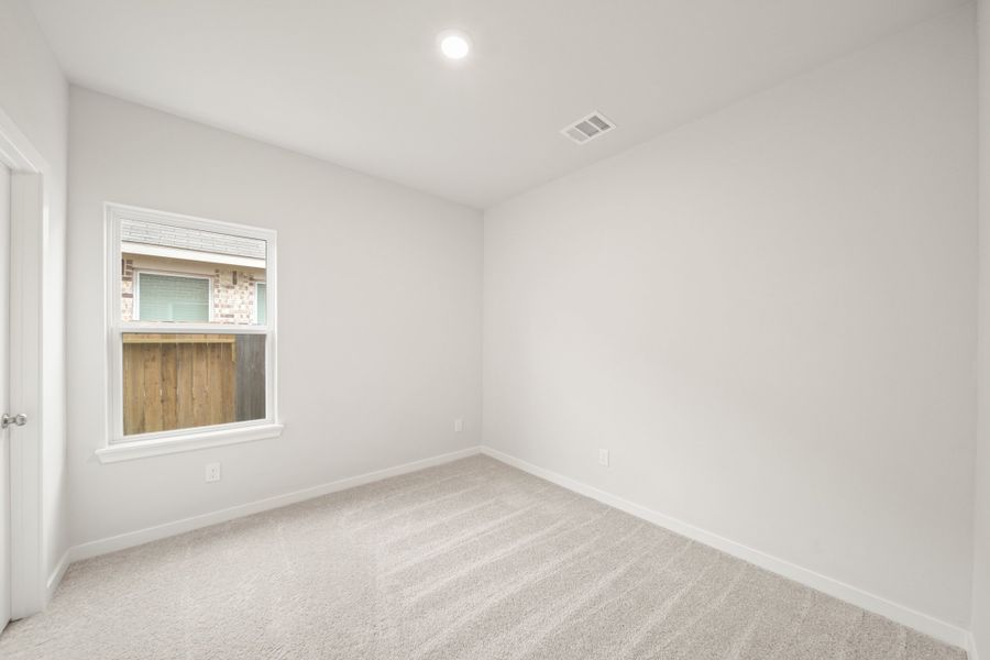 A room with a window and a carpet.