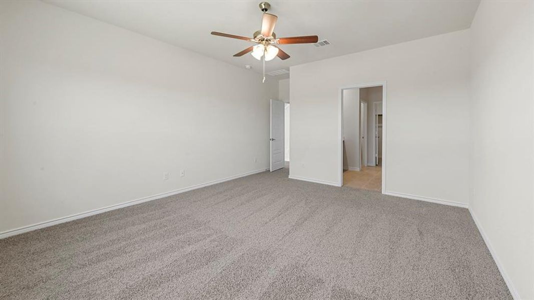 Unfurnished bedroom with light carpet and a ceiling fan