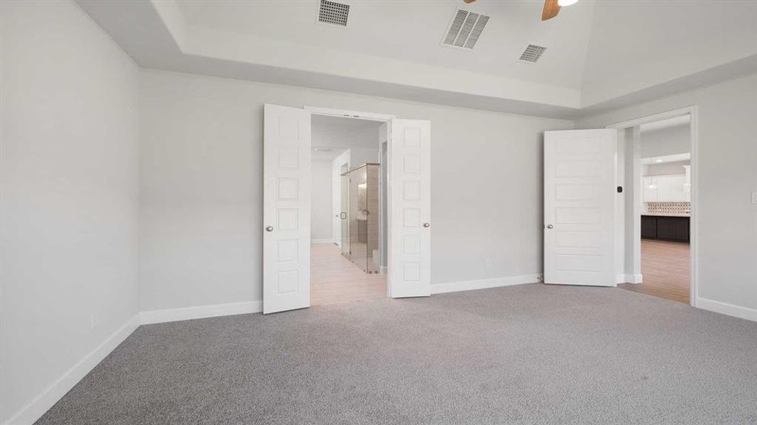 Unfurnished bedroom with ceiling fan, carpet flooring, and lofted ceiling