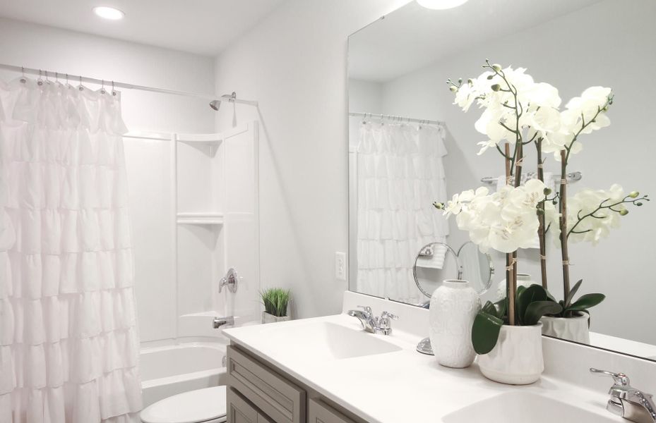 Secondary Bathroom with dual-sink vanity and shower tub combo
