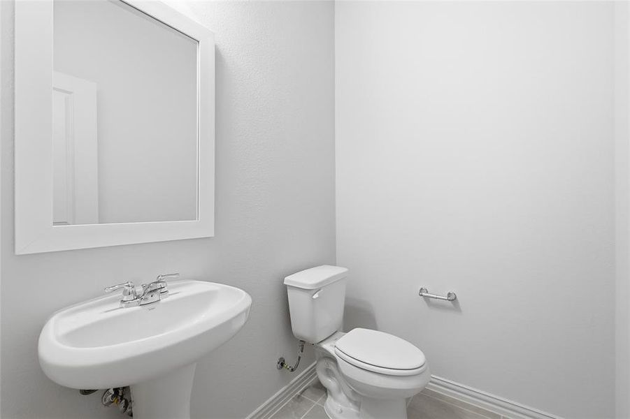 Half bathroom with baseboards and light tile patterned flooring