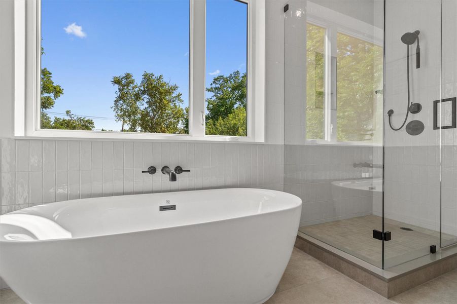 The bathroom is filled with natural light and also features a soaking tub and separate walk in shower. The bathroom is filled with natural light and also features a soaking tub and separate walk in shower.