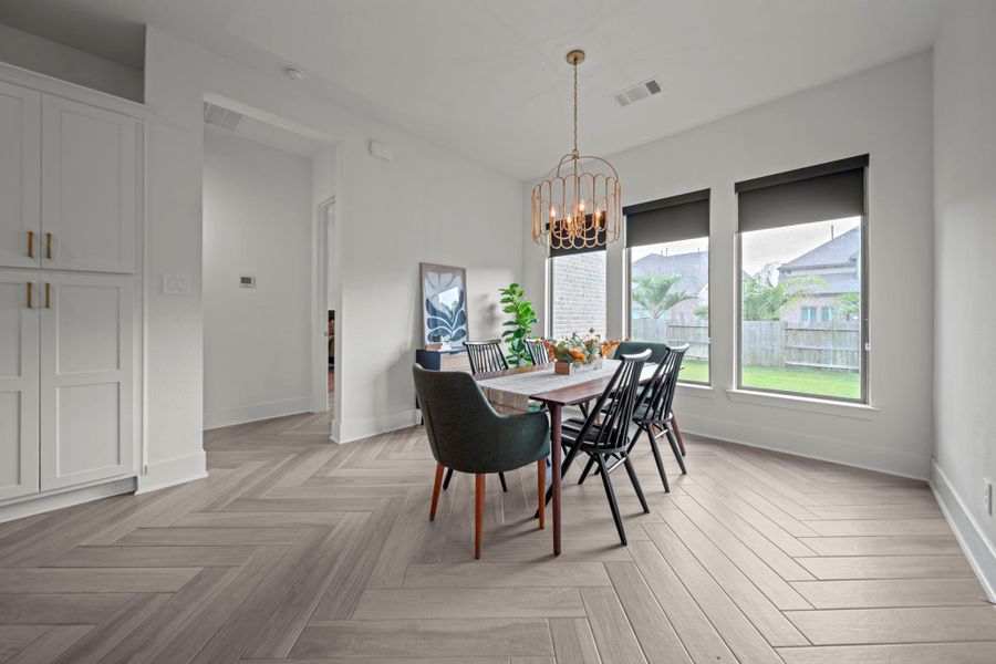 Bright dining space with modern chandelier and backyard views. A perfect spot for everyday meals or hosting guests. Bright dining space with modern chandelier and backyard views. A perfect spot for everyday meals or hosting guests.