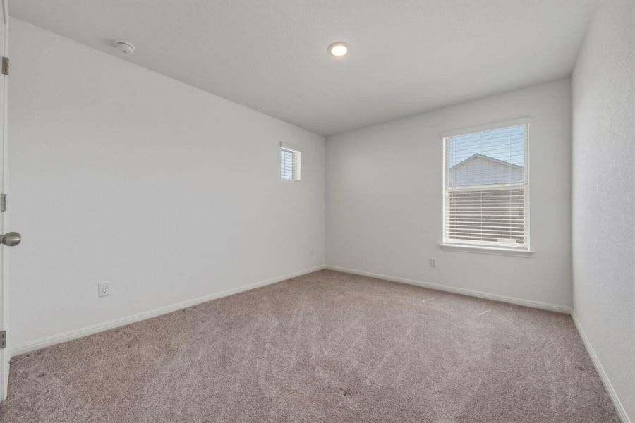 Empty room featuring light carpet and baseboards