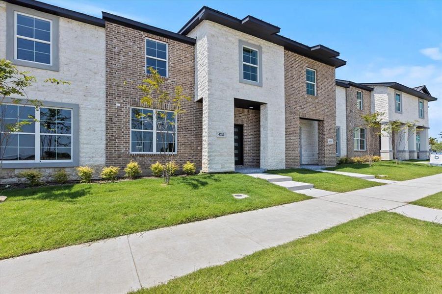 View of front of property featuring brick siding and a front yard