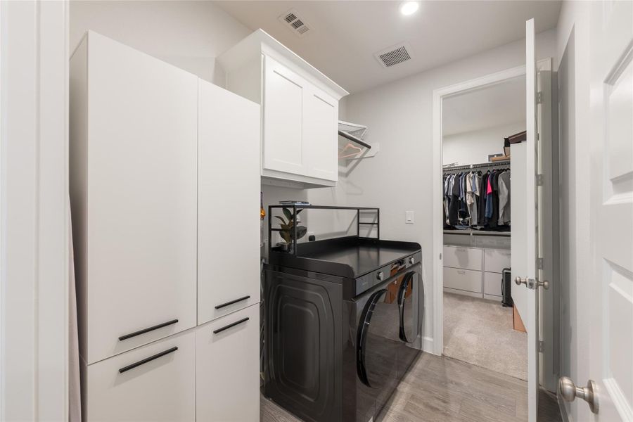 Convenient white cabinetry for storage, and access to a walk-in closet with ample hanging space. Convenient white cabinetry for storage, and access to a walk-in closet with ample hanging space.