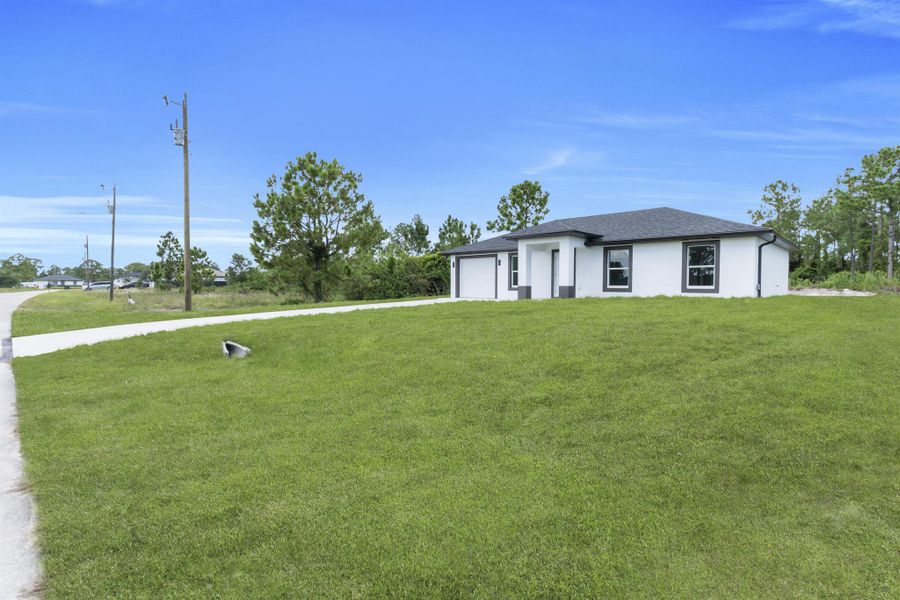 Front exterior of a new home in , Lehigh Acres, FL, highlighting curb appeal (Image 23).