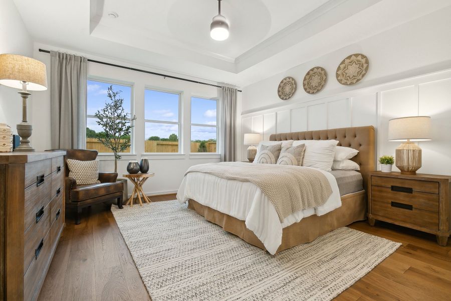 Primary suite with tray ceiling and decorative feature wall Primary suite with tray ceiling and decorative feature wall