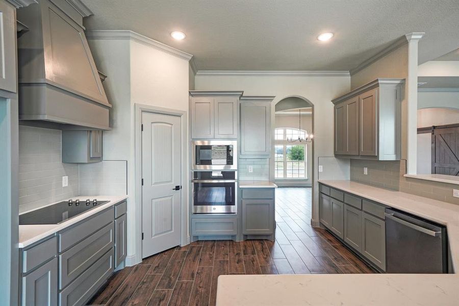 Kitchen with premium range hood, tasteful backsplash, and black appliances