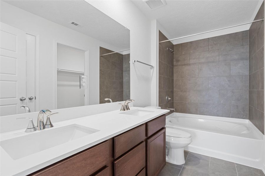This stunning primary bathroom is truly move-in ready! It features tub/shower combination with tile surround, stained cabinetry with light countertops, dual sinks, a large mirror, high ceilings, custom paint, a large window, and sleek modern finishes throughout. This stunning primary bathroom is truly move-in ready! It features tub/shower combination with tile surround, stained cabinetry with light countertops, dual sinks, a large mirror, high ceilings, custom paint, a large window, and sleek modern finishes throughout.