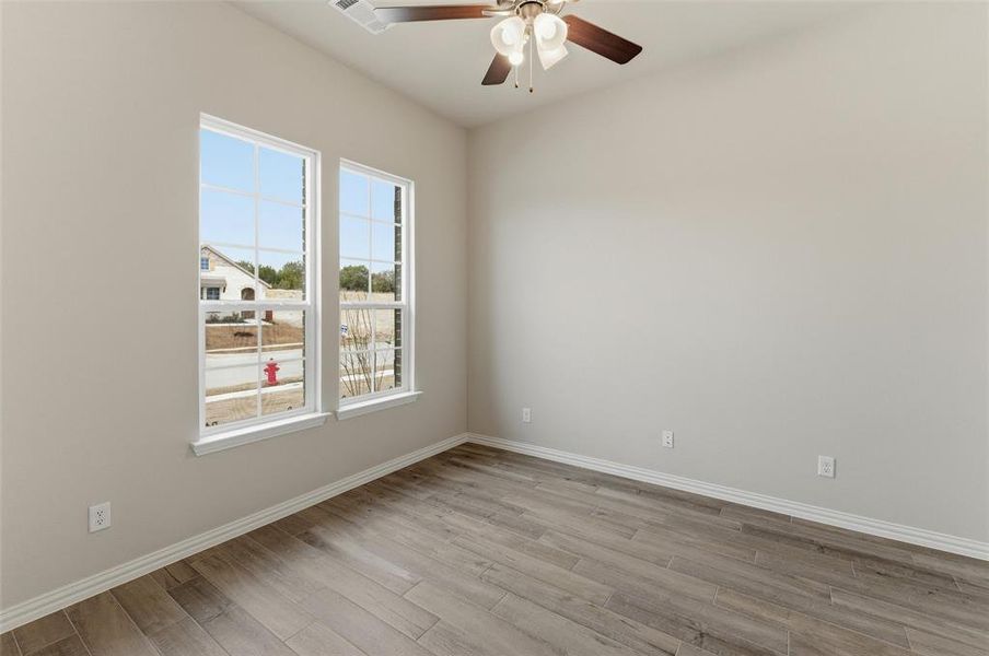 Spare room with a ceiling fan and light wood finished floors