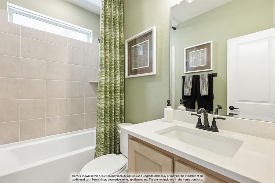 Bathroom with tiled tub and shower, single vanity with white countertop, and green walls