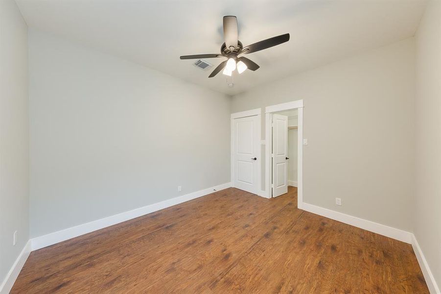 Comfortable secondary bedroom with a ceiling fan, providing a cool and relaxing space for rest and relaxation.