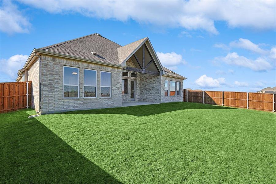 Back of property featuring a lawn and a patio area