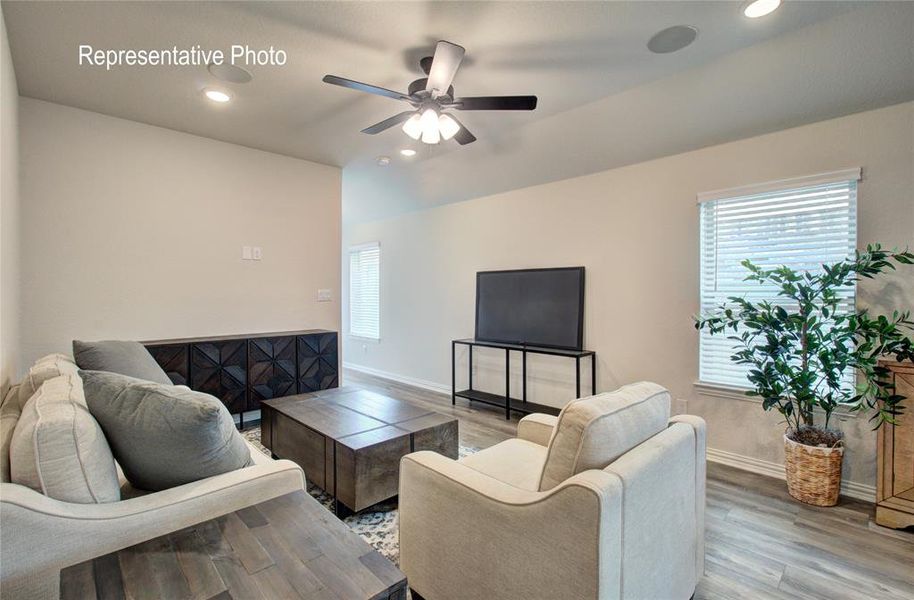 Living room with light hardwood / wood-style floors and ceiling fan