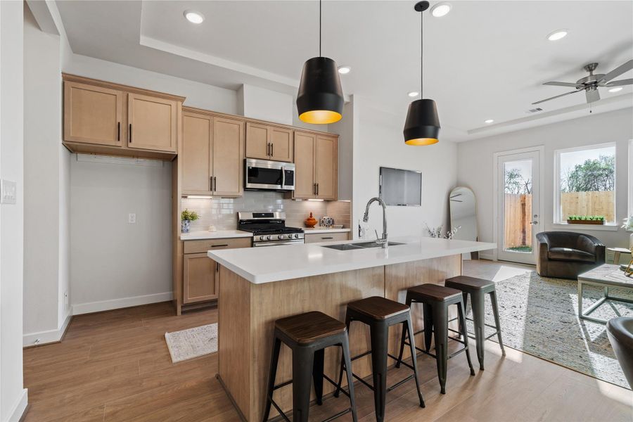 Engineered hardwood runs continuously from the kitchen through the dining and into the living area, tying the whole first floor together. Engineered hardwood runs continuously from the kitchen through the dining and into the living area, tying the whole first floor together.