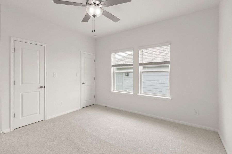 Unfurnished bedroom featuring light colored carpet and a ceiling fan