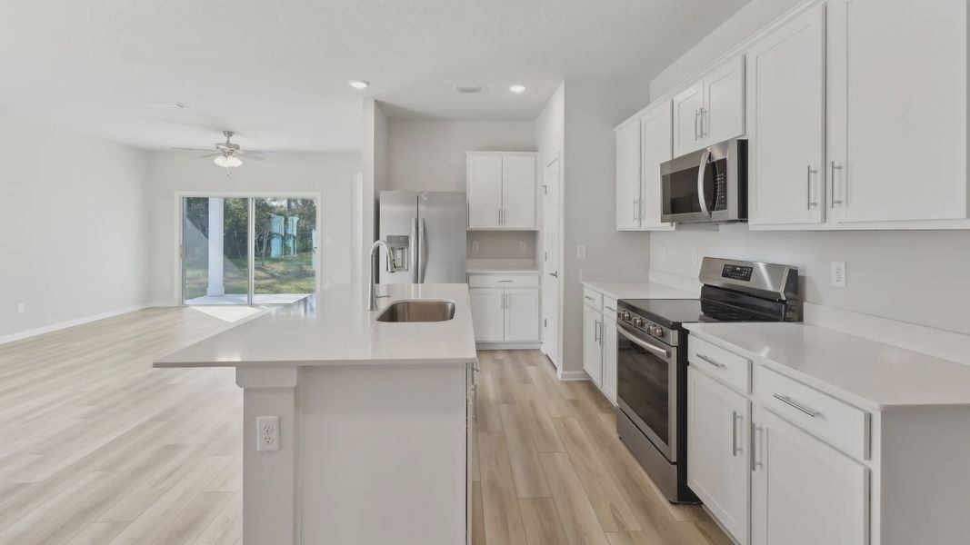 Elegant white cabinetry and sleek stainless appliances exude sophistication in this Merritt at Palm Coast gem.