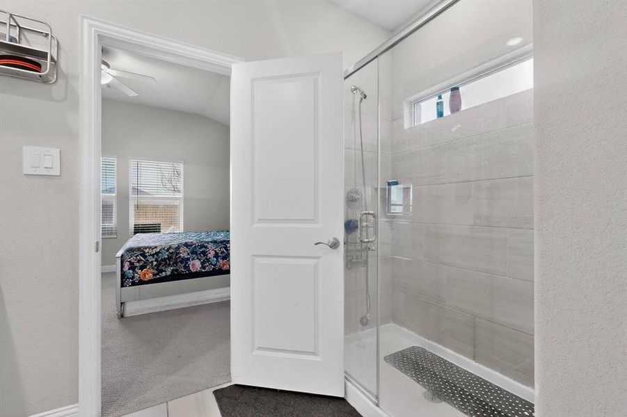 Ensuite bathroom with a stall shower and a textured wall Ensuite bathroom with a stall shower and a textured wall