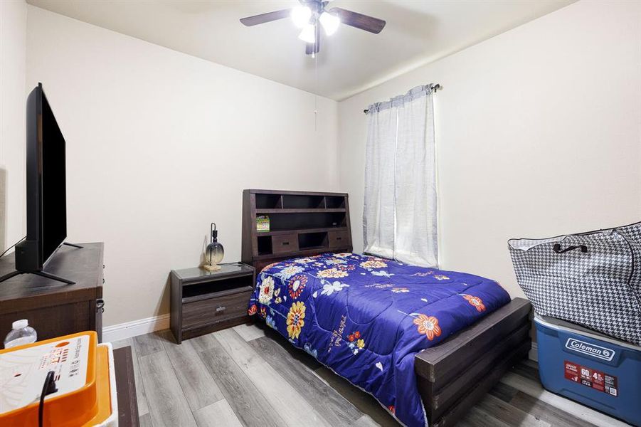 Bedroom with ceiling fan and light hardwood / wood-style flooring