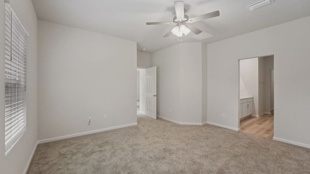 Luxurious Palm Coast bedroom with elegant plush carpeting and sophisticated ceiling fan, offering serene comfort.