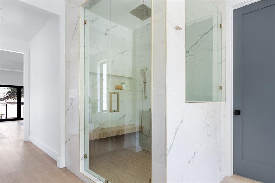 Bathroom with a shower with door and hardwood / wood-style floors