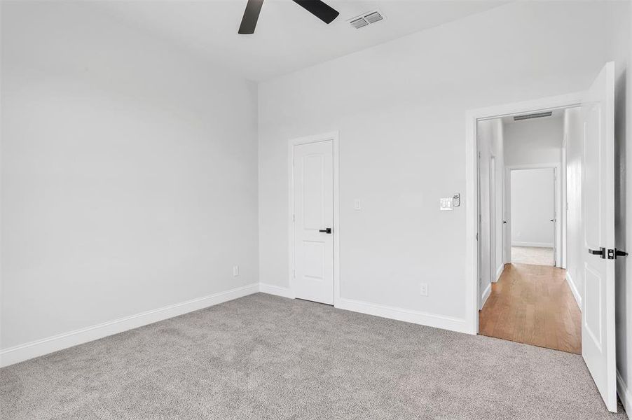 Unfurnished bedroom featuring light carpet and ceiling fan