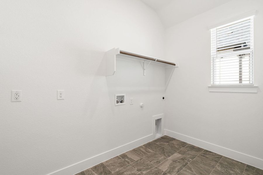 A well-appointed laundry space features practical hanging storage and tiled flooring.