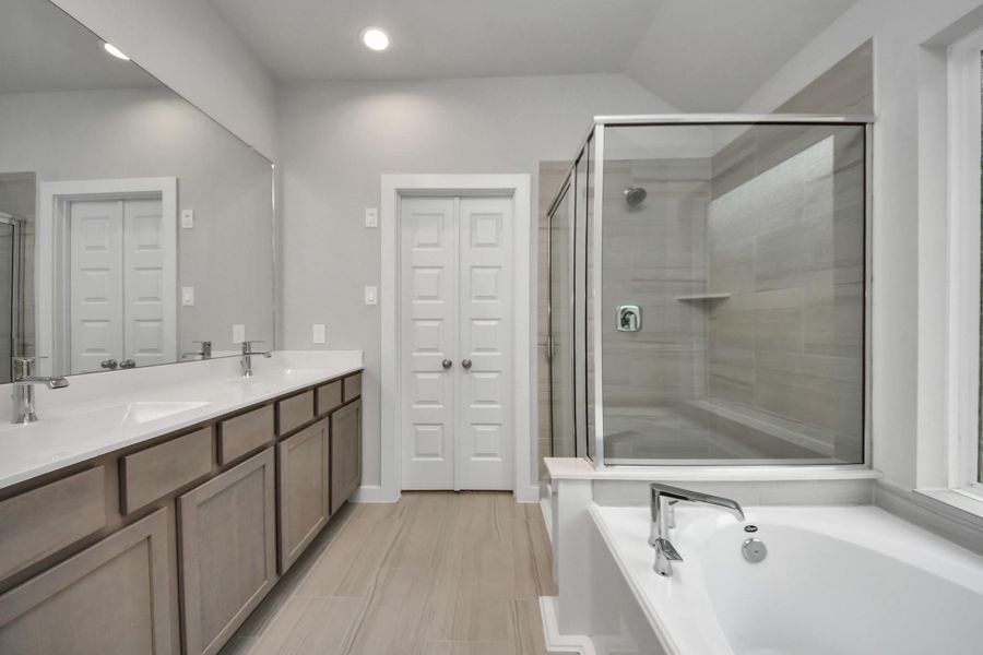 Elevate your dailyroutine at the elegant vanity, now equipped with double sinks, lightcountertops, modern hardware, and beautiful recessed lights. Sample photo of completed home with similar floor plan. Actual colors and selections may vary.