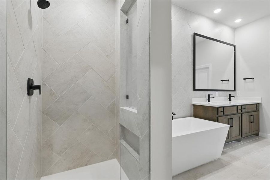 Bathroom with double vanity, a freestanding bath, tiled shower, and recessed lighting