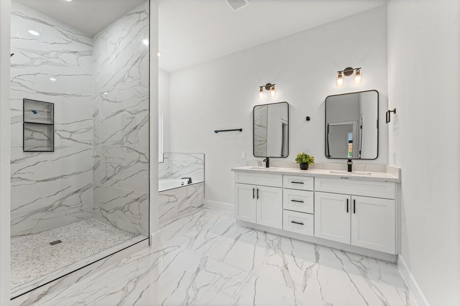 Luxurious bath with double-sink vanity, walk-in shower, and a relaxing soaking tub. Photos are representative of the same floor plan built by this builder. Finishes will be the same or similar.