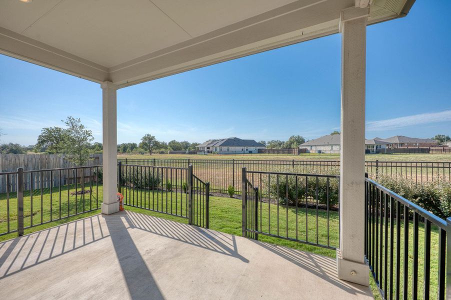 A spacious covered patio overlooks a large fenced yard with expansive neighborhood views.