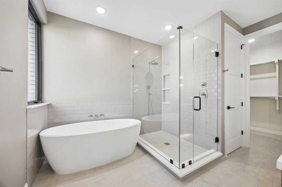 Bathroom with a walk in closet, a freestanding tub, a shower stall, tile walls, and recessed lighting Bathroom with a walk in closet, a freestanding tub, a shower stall, tile walls, and recessed lighting