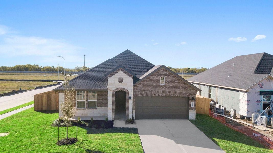 Newly built single story home with traditional architecture, a double garage, and landscaped front yard.