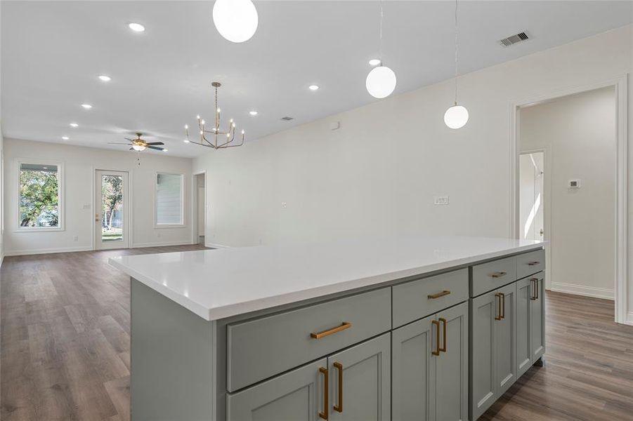Kitchen with pendant lighting, ceiling fan, open floor plan, a kitchen island, and recessed lighting Kitchen with pendant lighting, ceiling fan, open floor plan, a kitchen island, and recessed lighting