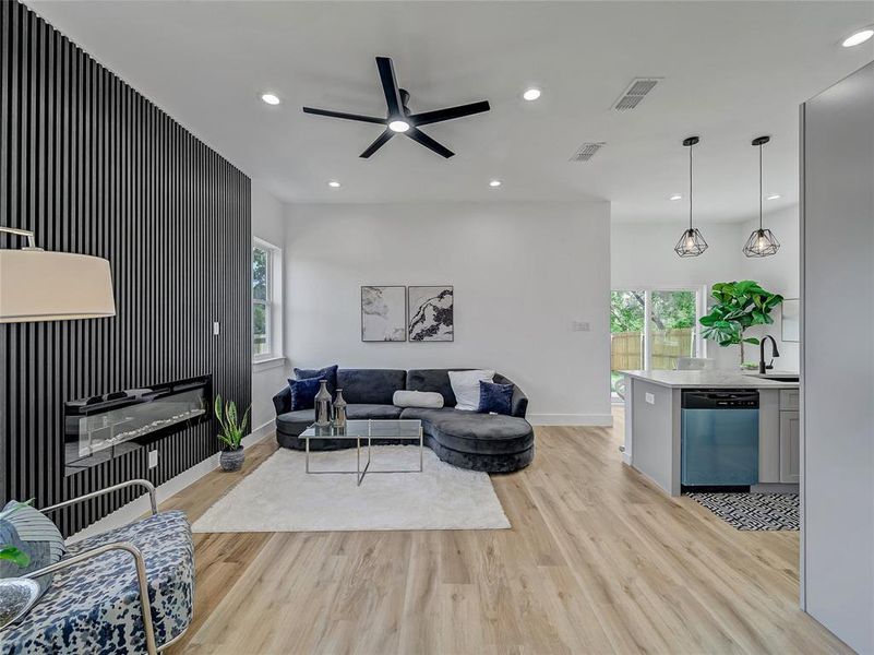 Living room with sink, ceiling fan, and light wood-type flooring