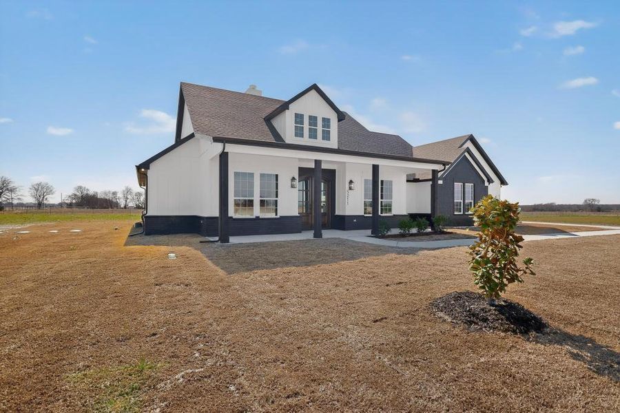 Modern farmhouse style home featuring a porch and a shingled roof
