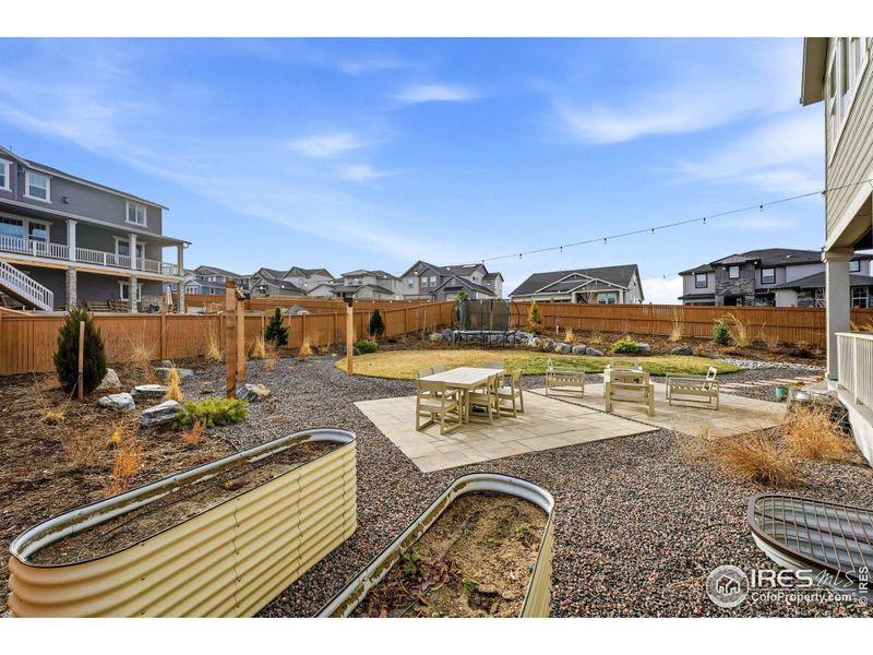 A thoughtfully designed backyard with raised garden beds, patio space, and room to relax, gather, or simply enjoy time outdoors.