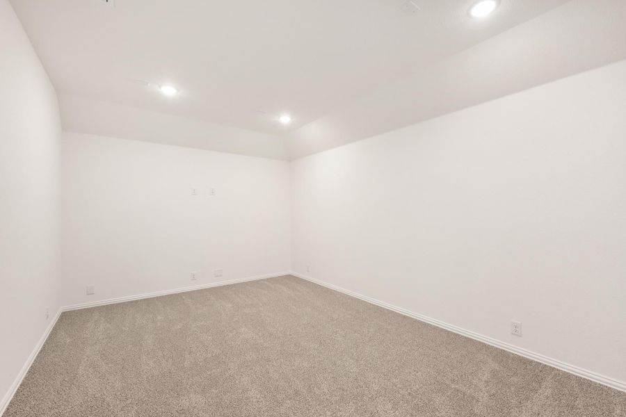 Empty room with gray carpet, white walls, and recessed ceiling lights