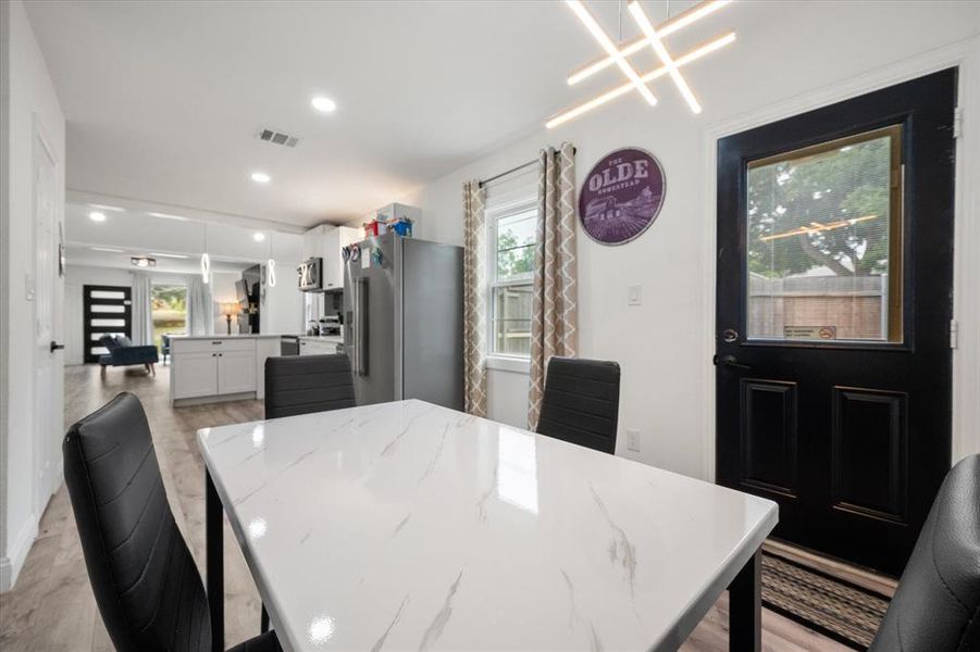 Dining area with light wood-style flooring and recessed lighting Dining area with light wood-style flooring and recessed lighting